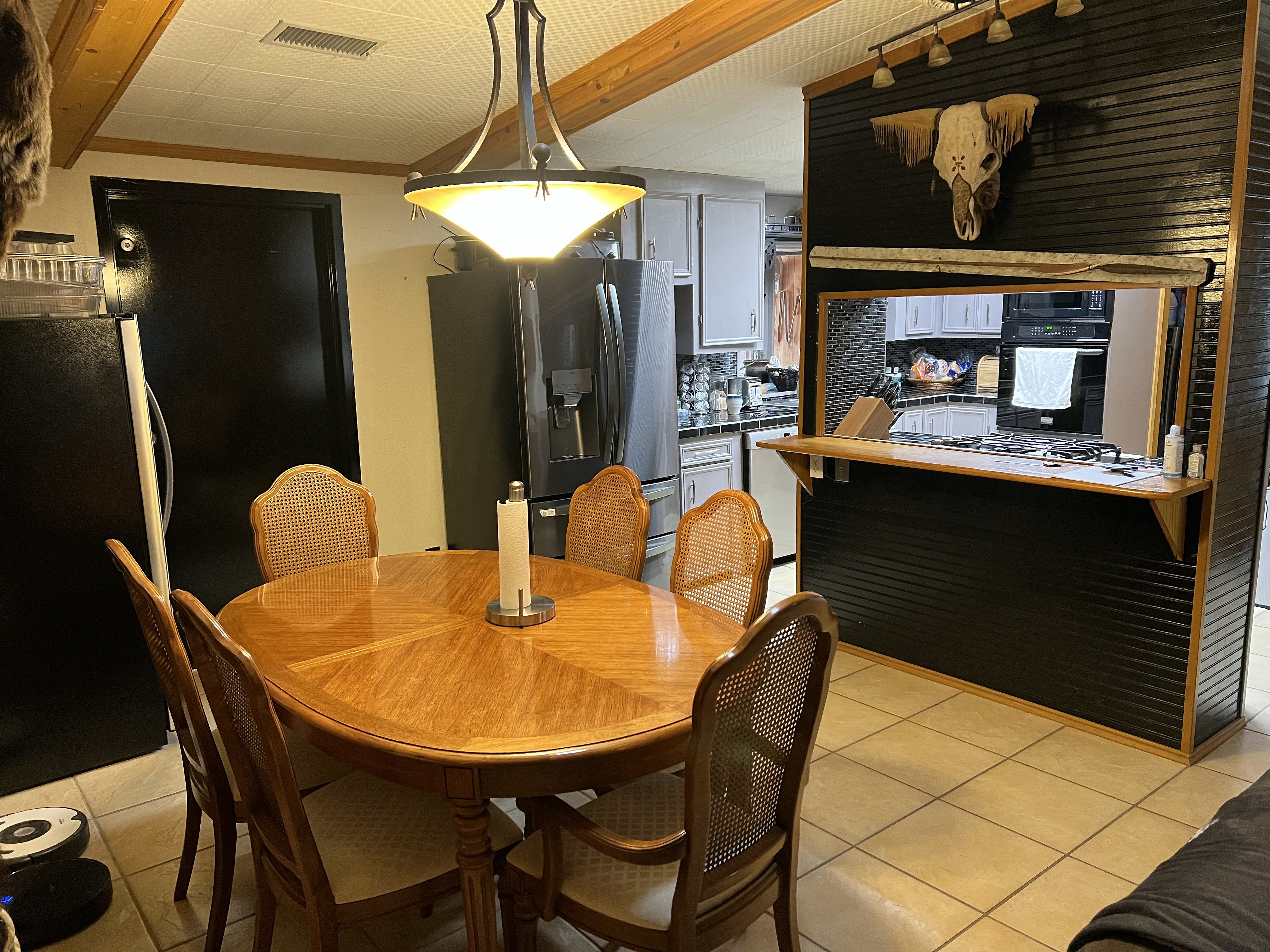 Buckhorn dining area before — alternate angle showing original round table, pass-through to kitchen and adjacent spaces