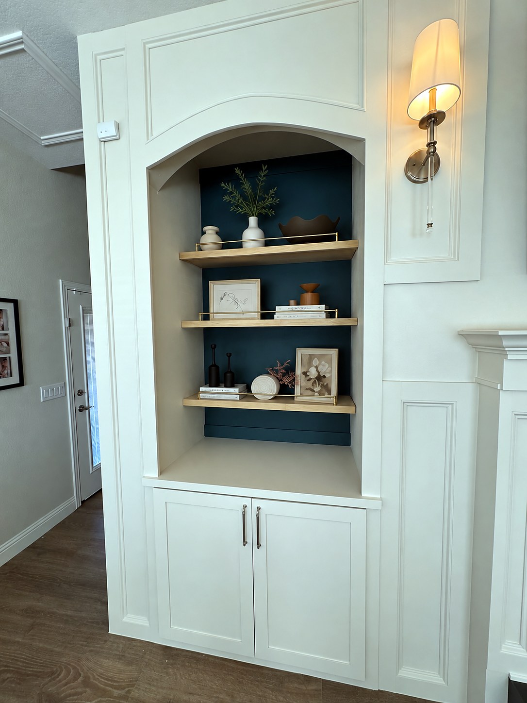 Half Moon fireplace remodel — completed arched built-in niche with teal backing, wood shelves and styled decor, 940 Interiors