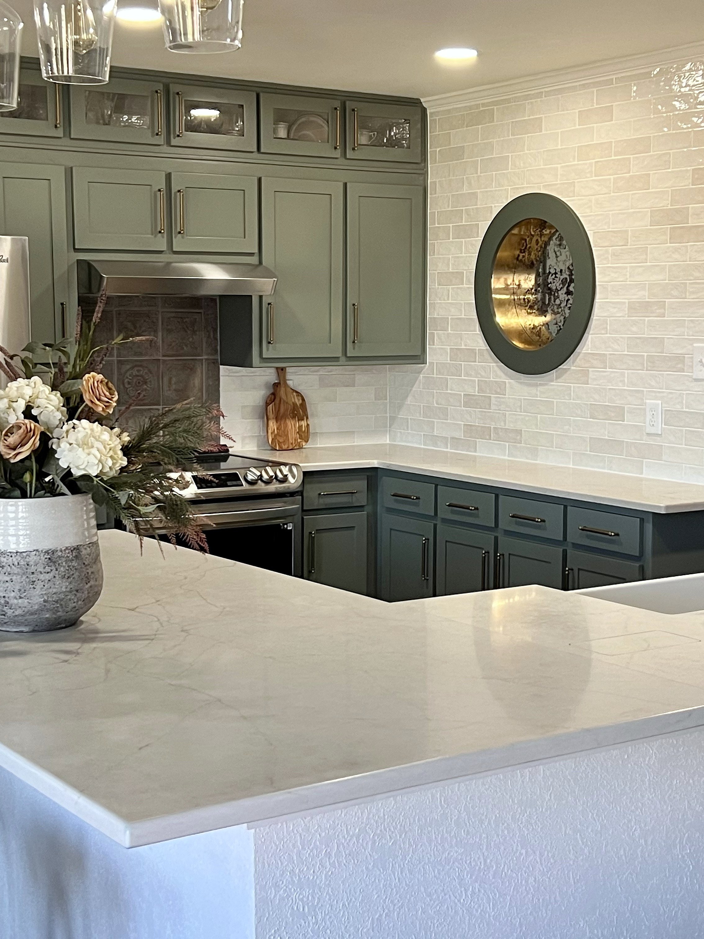 Millbrook kitchen renovation — sage cabinets to ceiling, marble island and round porthole window, 940 Interiors