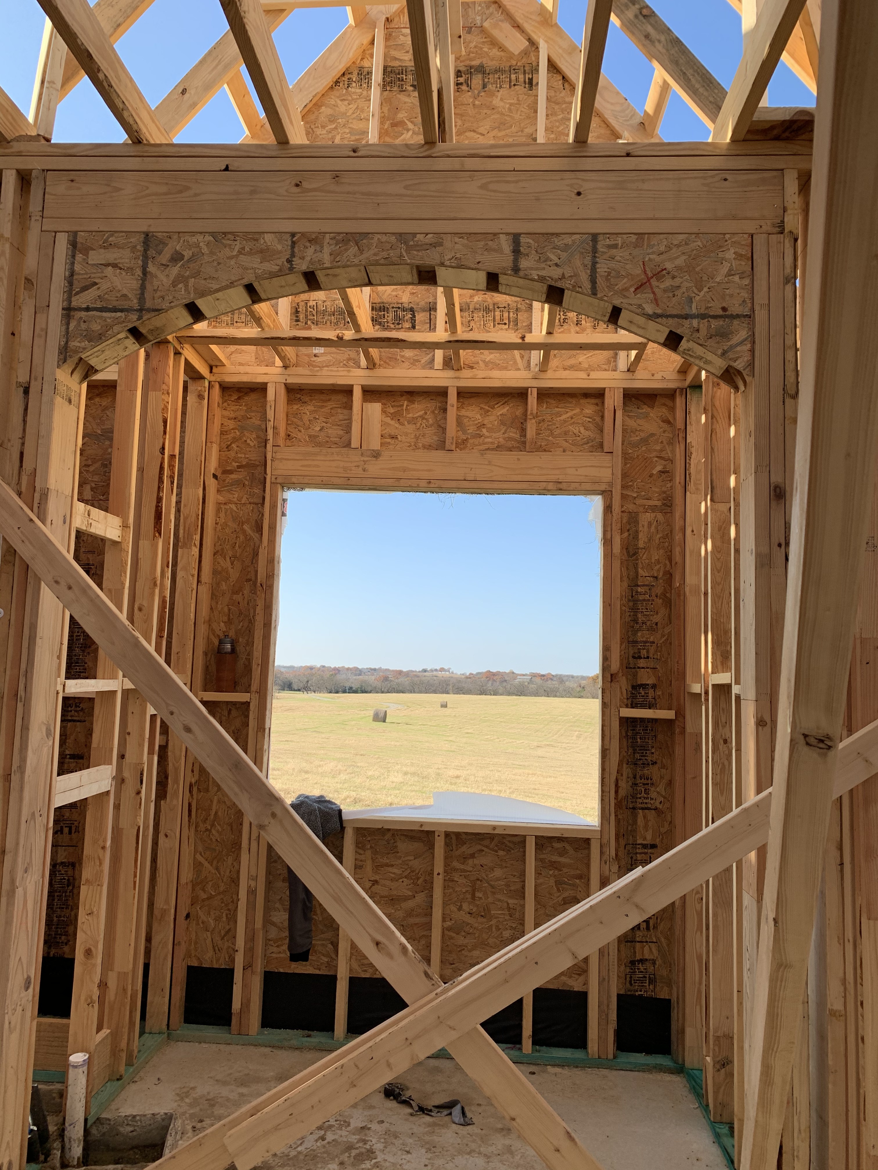Old Gin new build — arched doorway framing the open land beyond