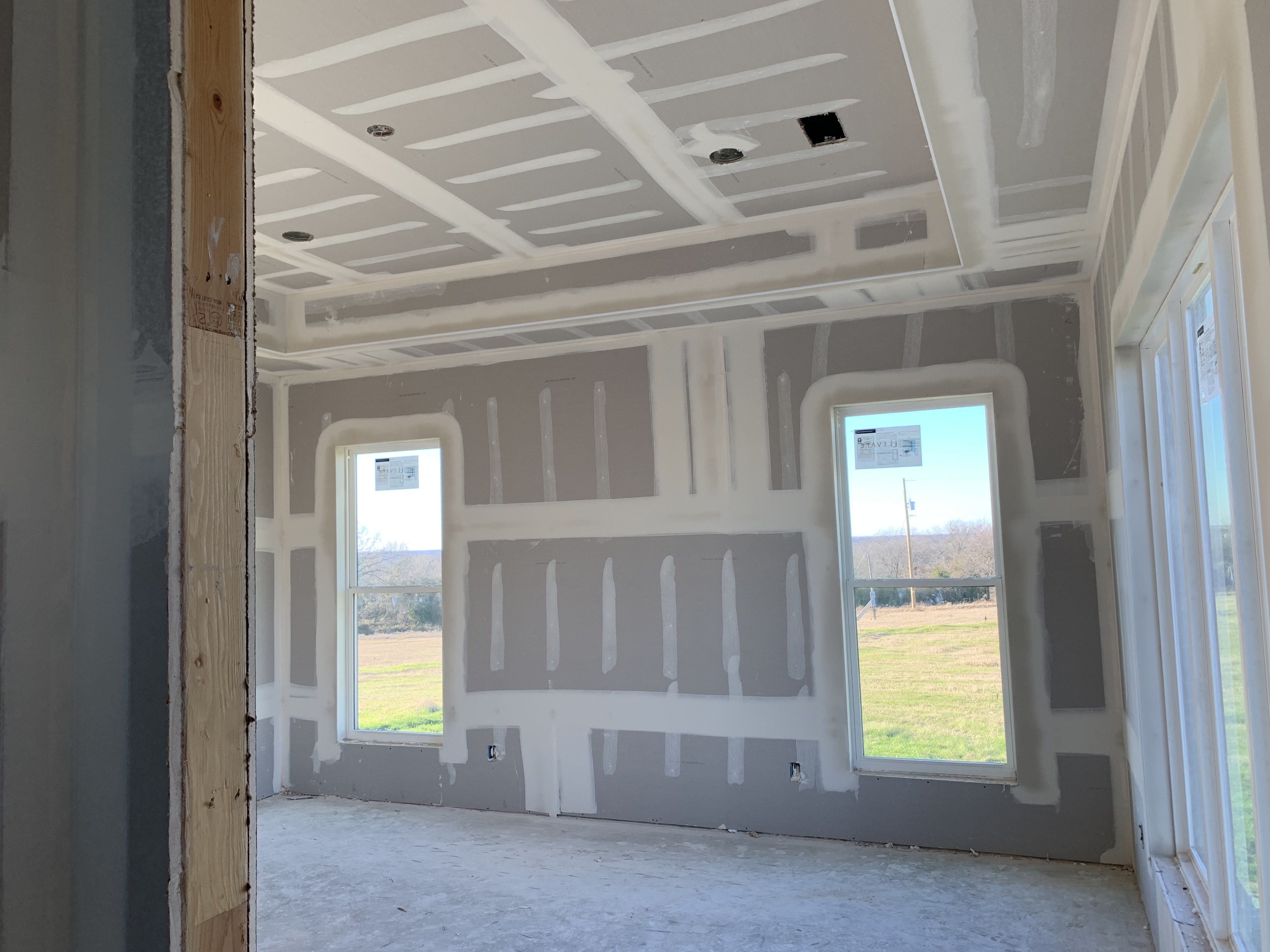 Old Gin new build — room at drywall stage with pond-view windows