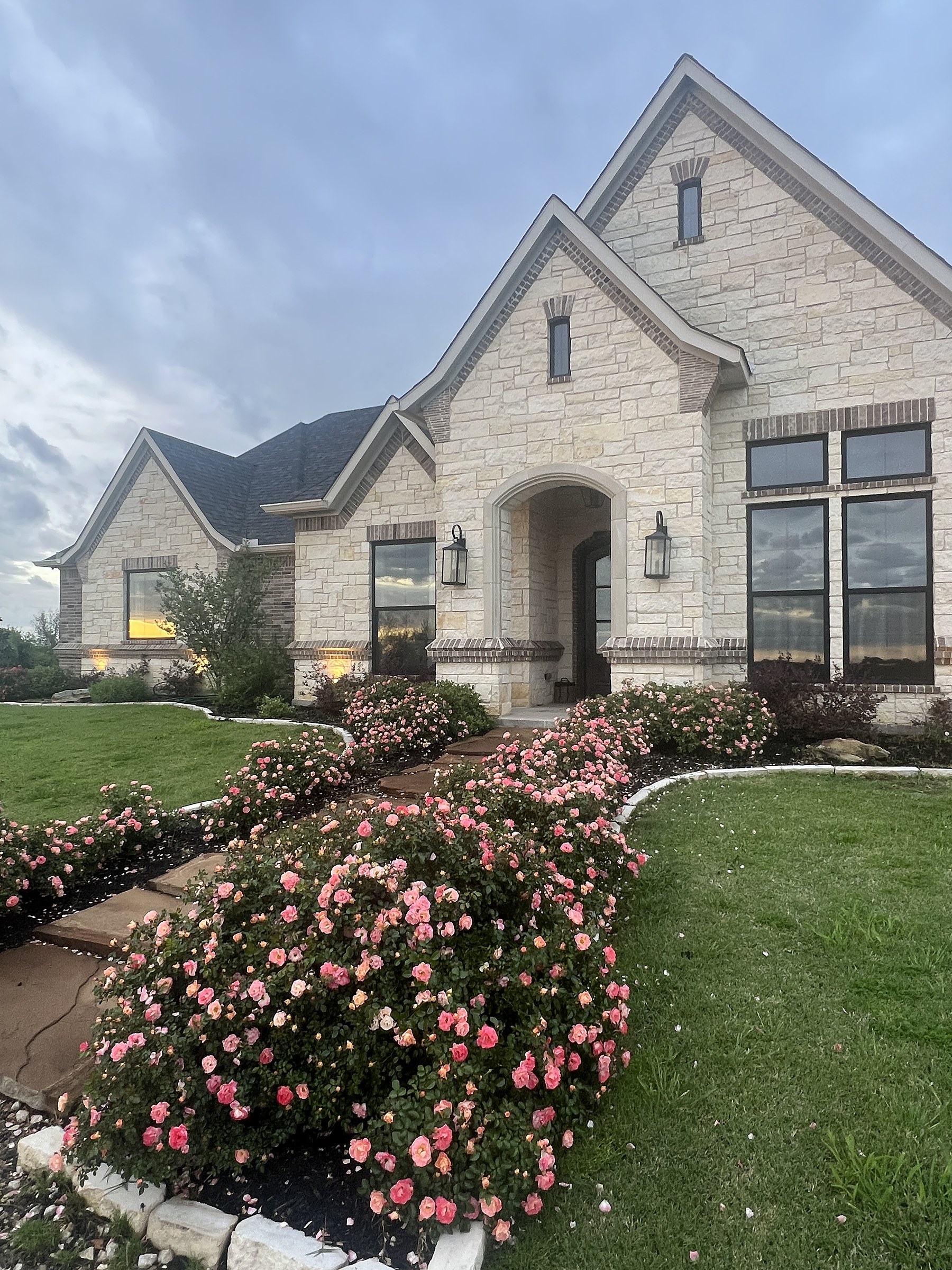 Old Gin new build — completed facade with rose garden and Texas land backdrop