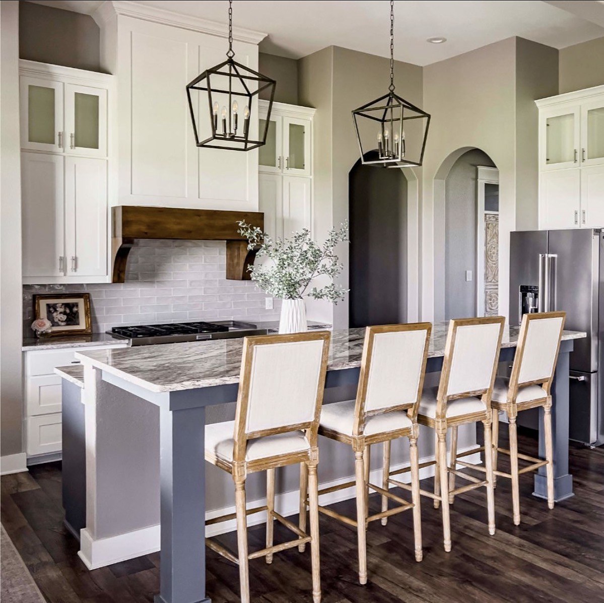 Old Gin kitchen — white cabinetry, marble island and lantern pendants