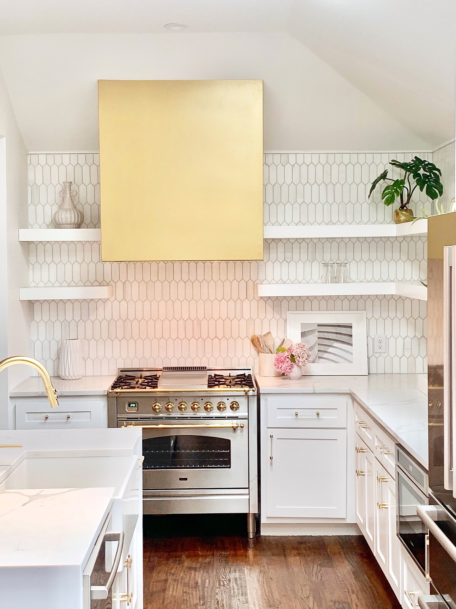 Summer Glen renovation — kitchen overview with gold hood, island and range