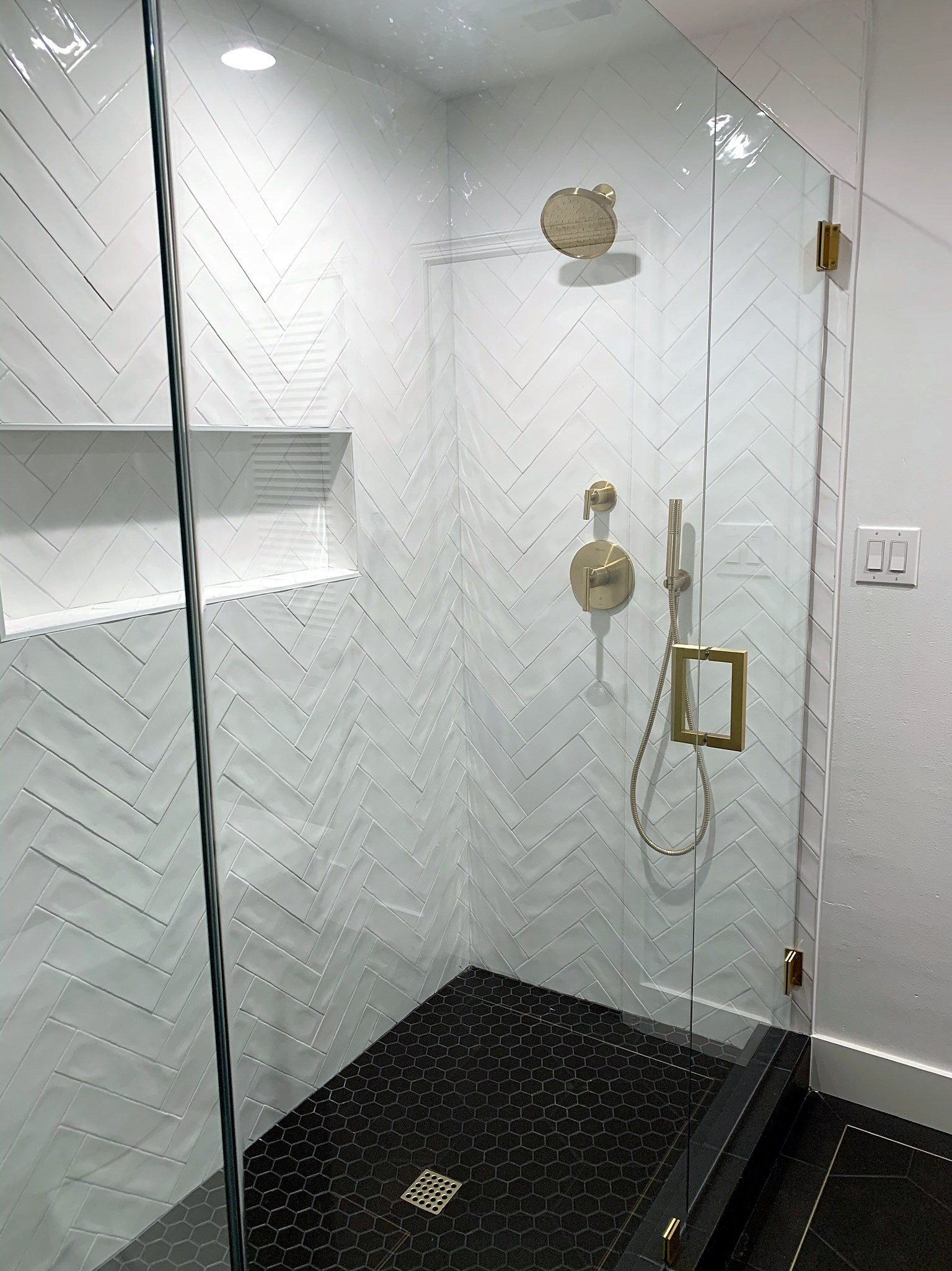 Summer Glen renovation — shower with herringbone tile, niches and brass fixtures
