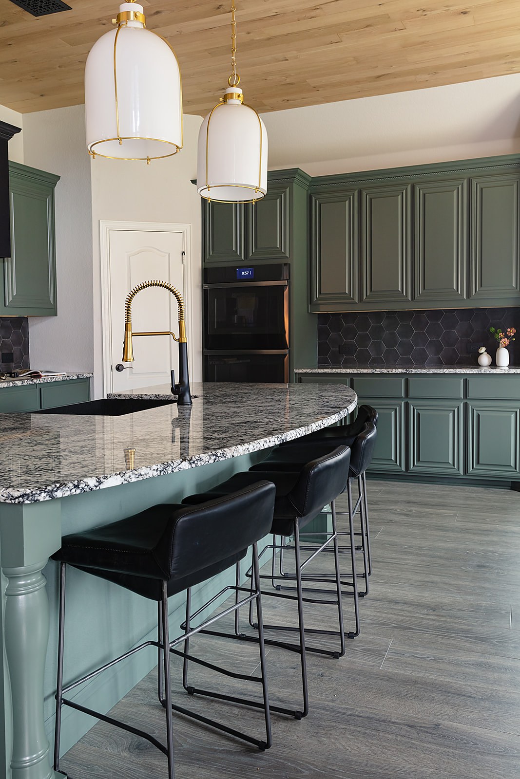 Strait Lane kitchen — deep green cabinetry with glossy black tile and island