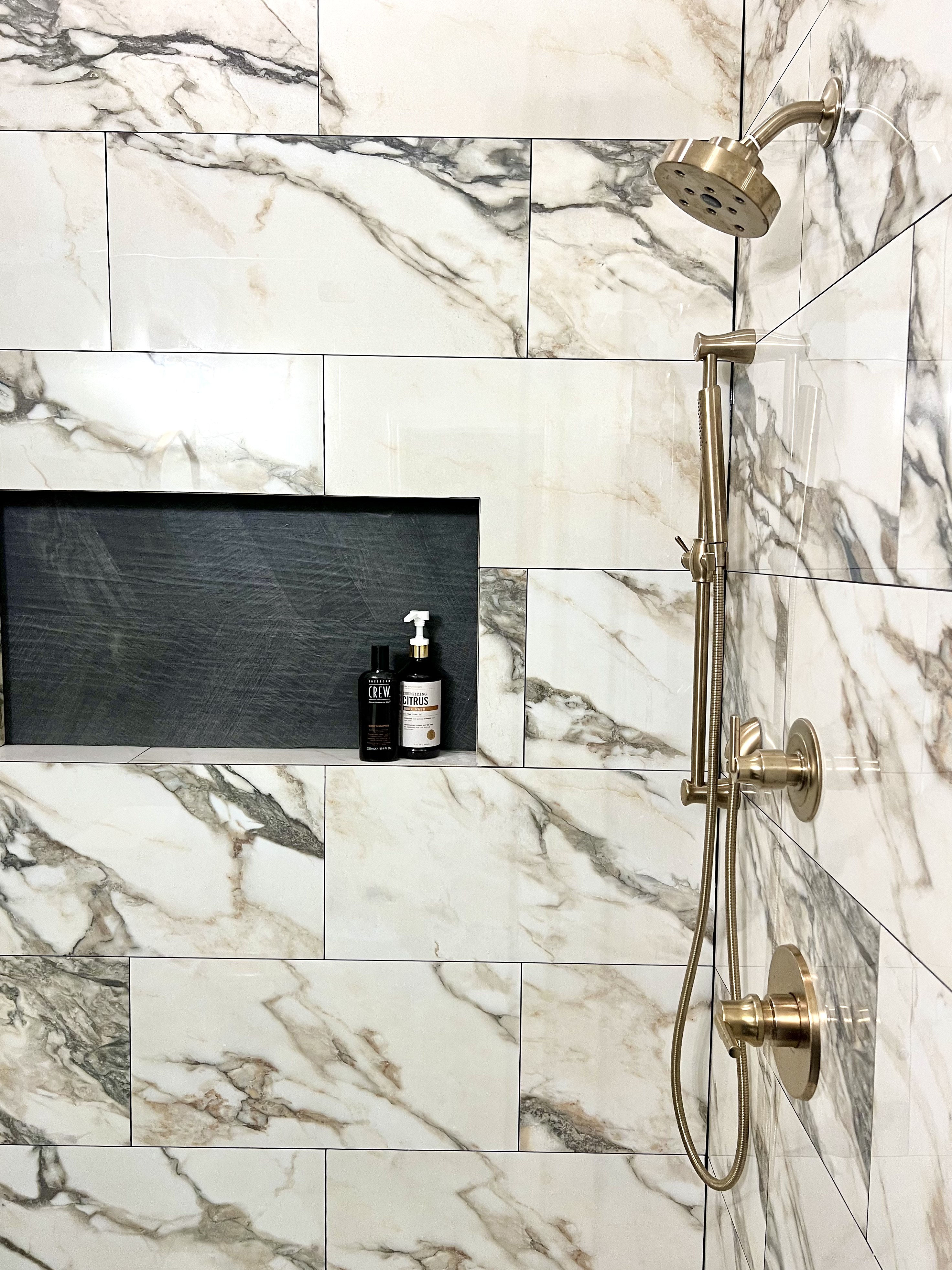 Shady Oaks — masculine shower niche with dark slate inset, products and brass handshower detail