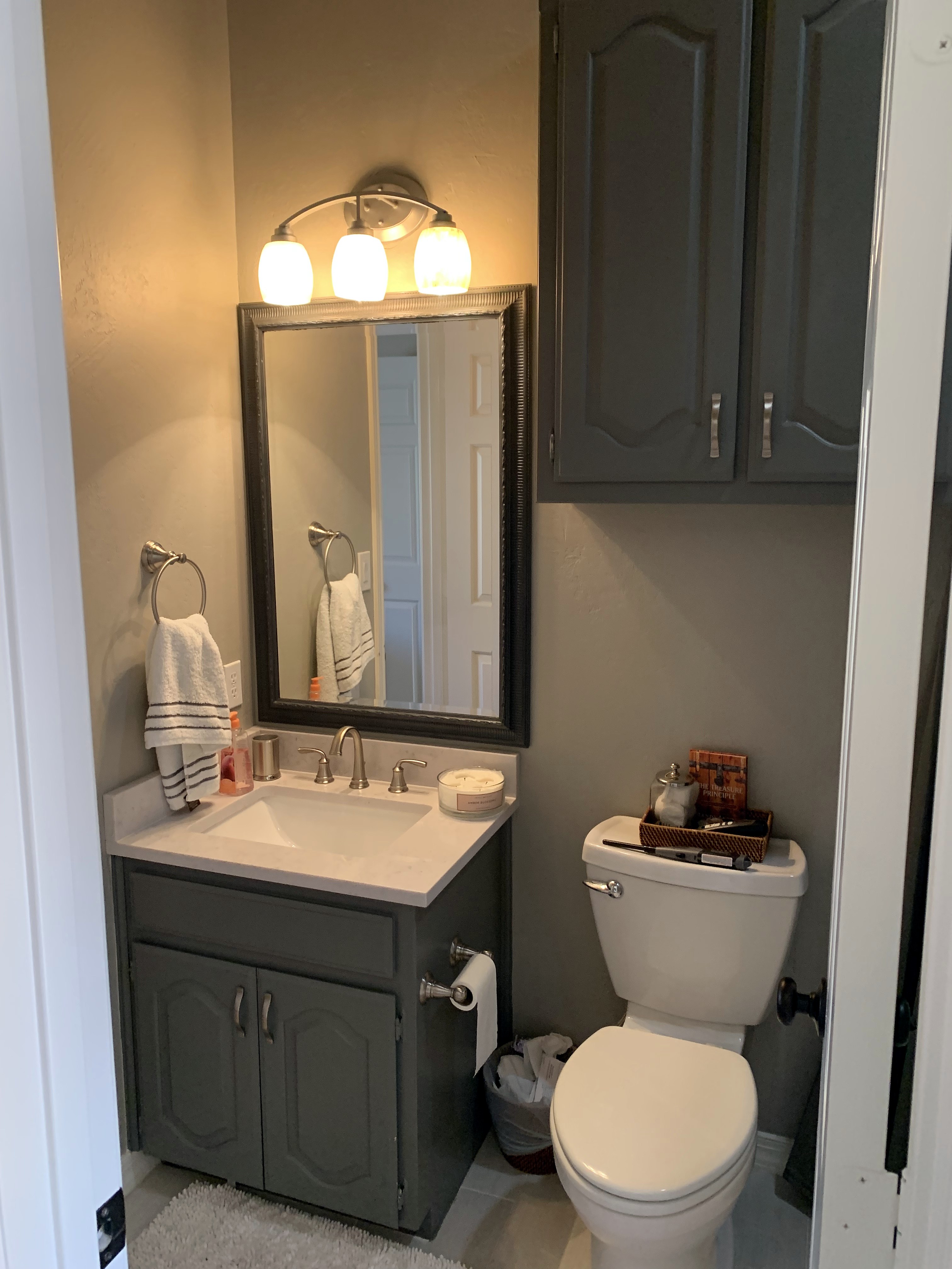 Shady Oaks — masculine bathroom before renovation, original vanity with dark framed mirror