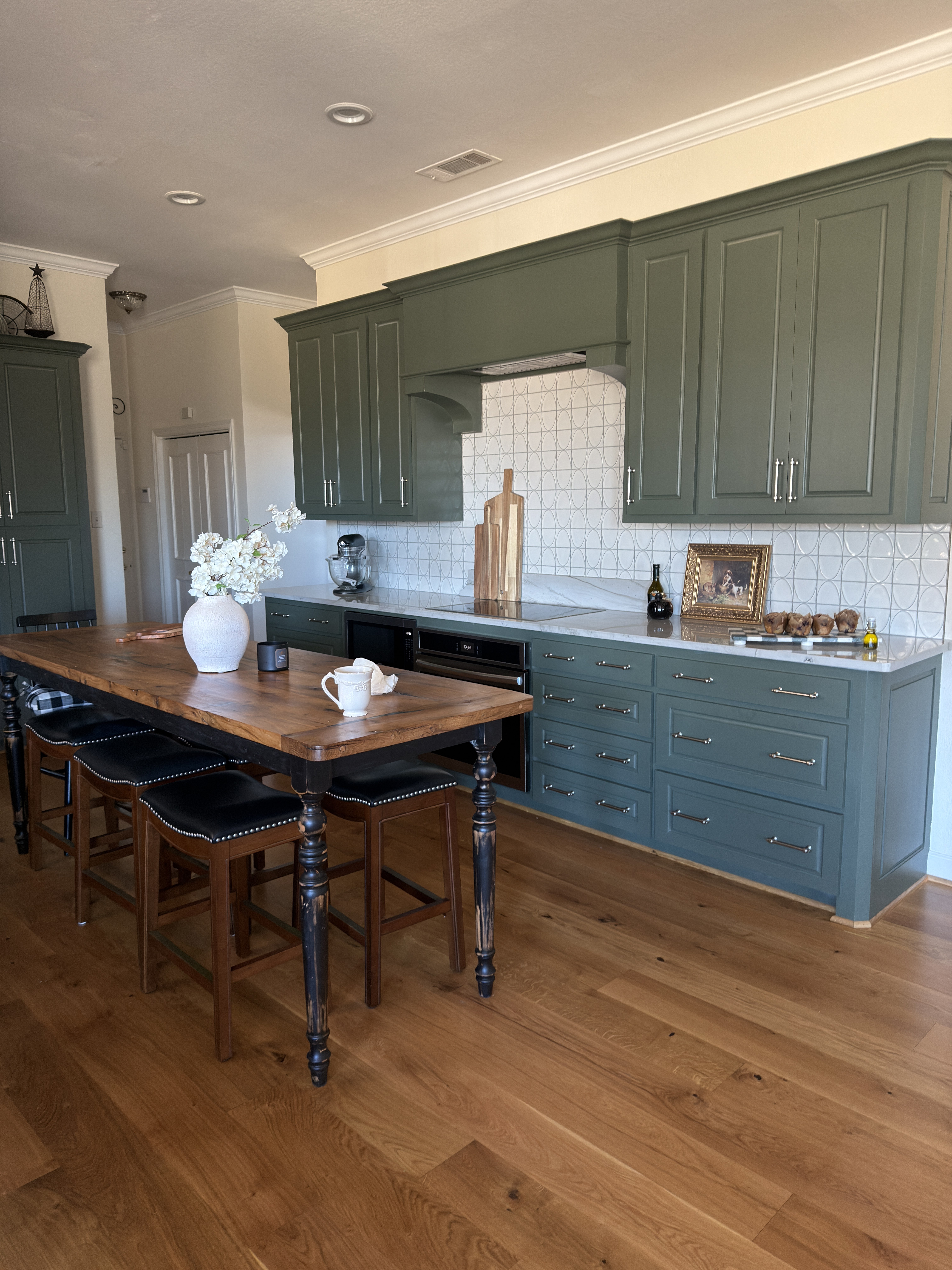 Sugar Ridge kitchen — green cabinetry, geometric backsplash, farmhouse island table